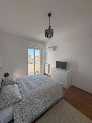 a white bedroom with a bed and a television at Casa Francesco in Rapallo
