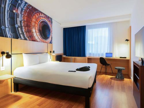 a hotel room with a large bed and a desk at ibis Genève Petit Lancy in Geneva