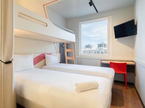 a small room with two beds and a window at ibis budget Genève Petit-Lancy in Geneva
