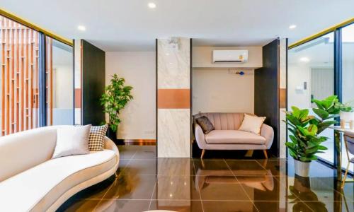 a living room with a couch and a chair at Bangkok Esque Sukhumvit101 Condo NEW Building in Amphoe Phra Khanong