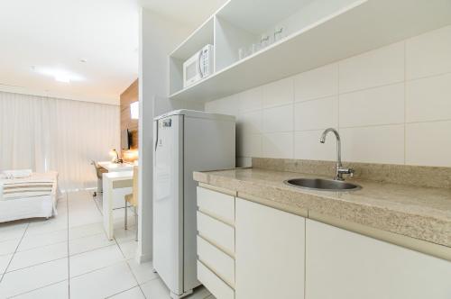 a white kitchen with a sink and a refrigerator at Vision Hotel em Brasília 84573 in Brasília