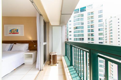 a bedroom with a bed and a balcony with buildings at Vision Hotel em Brasília 84573 in Brasília