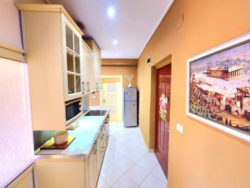 a kitchen with yellow walls and a large painting on the wall at Apartament me qira ditore "AGA"Fier in Fier