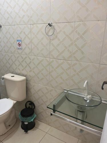 a bathroom with a glass sink and a toilet at Surf Zone Hostel in Saquarema