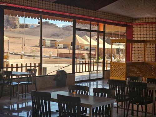 a restaurant with tables and chairs and a view of the desert at Camp sami in Disah