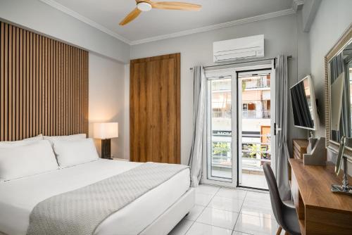 a bedroom with a bed and a desk and a television at Corfu City Center Design Residence incl private parking in Corfu