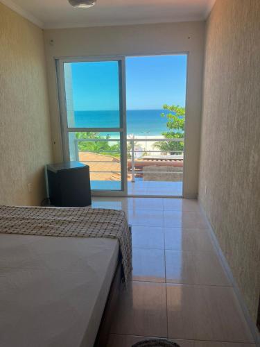a bedroom with a bed and a view of the ocean at Surf Zone Hostel in Saquarema