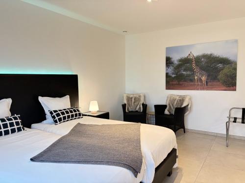 a bedroom with two beds and a giraffe painting on the wall at Vita Roka met extra Luxe Privé Wellness in Ursel