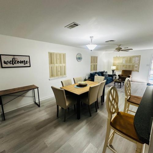 a dining room and living room with a table and chairs at Feels like HOME escape, 1/2 Mile to beach in Gulfport