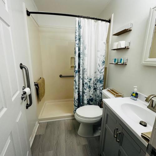 a bathroom with a toilet and a shower curtain at Feels like HOME escape, 1/2 Mile to beach in Gulfport