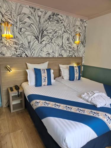 une chambre avec un grand lit aux oreillers bleus et blancs dans l'établissement Amadeus Hotel, à Paris