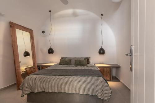 a bedroom with a bed with two pillows on it at Casa Grande Santorini in Megalochori