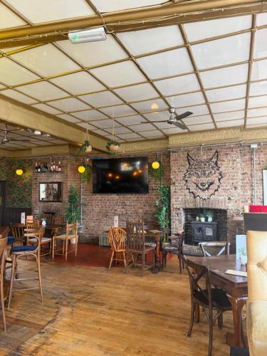 a restaurant with tables and chairs and a brick wall at The Wolfs Tavern in London