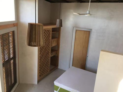 a room with a table and a shelf and a lamp at Poolside Cabaña Studio with stunning ocean view in Puerto Escondido