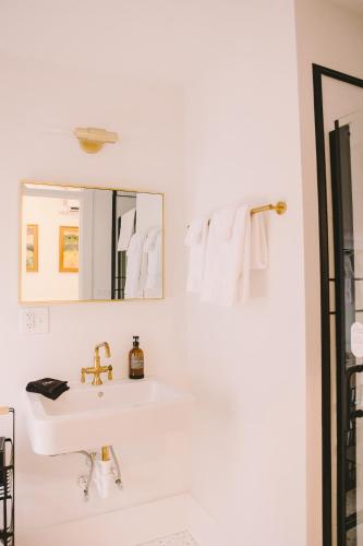 a white bathroom with a sink and a mirror at The Historic Hattie House in Abingdon