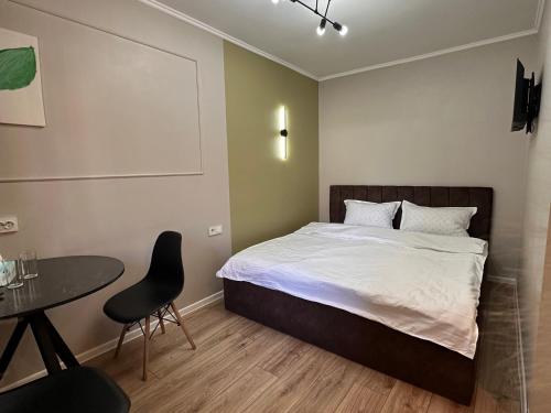 a bedroom with a bed and a table and a chair at Meridian Hotel in Almaty