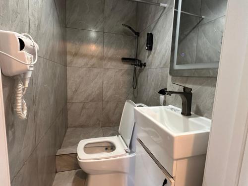 a small bathroom with a toilet and a sink at Meridian Hotel in Almaty