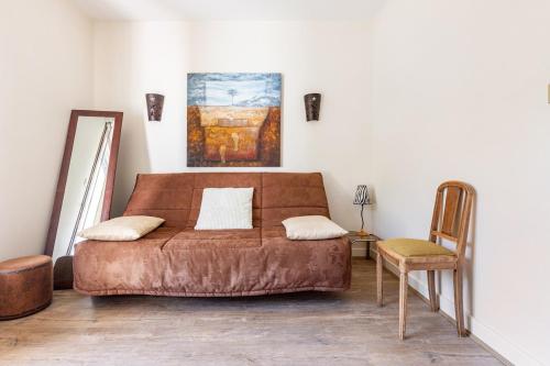 a couch in a room with a chair and a painting at Sérénité in Jussac