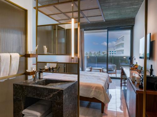 a bedroom with a sink and a bed with a view at The Nines in Ayia Napa
