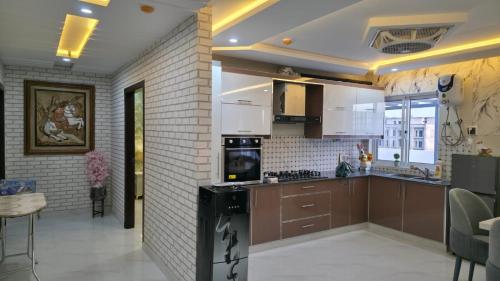 a kitchen with brown cabinets and a brick wall at Skyline Central Apartments in Islamabad