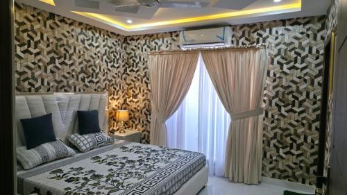 a bedroom with a bed and a large window at Skyline Central Apartments in Islamabad