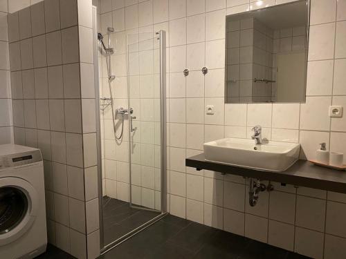 a bathroom with a sink and a washing machine at Ferienwohnung Sonnenplatz in Fehmarn