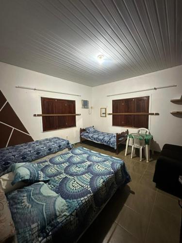 a bedroom with two beds and a table in it at Casa em Alter do Chão in Santarém