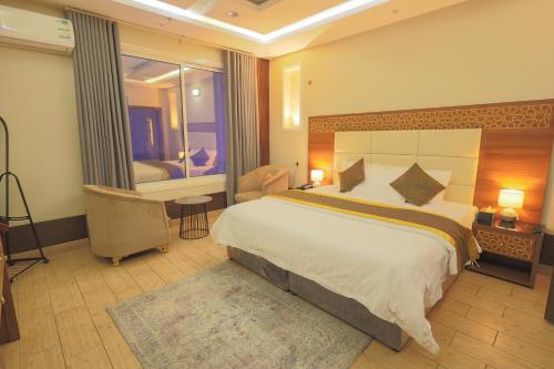 a hotel room with a large bed and a window at منتجع و شاليهات المخمل Velvet Chalets and resort in Taif