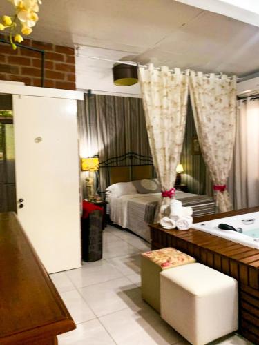 a bedroom with a bed and a bathtub and a room with a tub at Cabana Refúgio do Recanto in São Valentim do Sul
