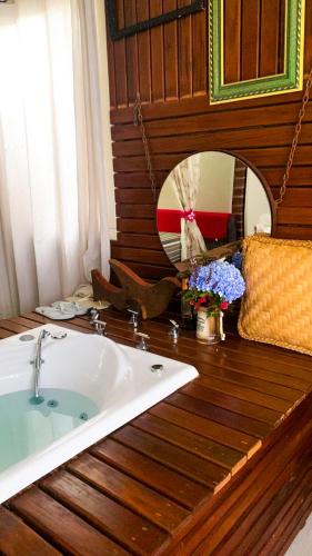 a bathroom with a sink and a mirror on a wooden table at Cabana Refúgio do Recanto in São Valentim do Sul