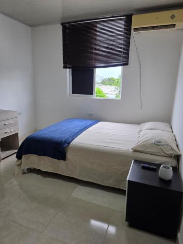 a bedroom with a large bed with a window at El apartacho de Andres in Valledupar