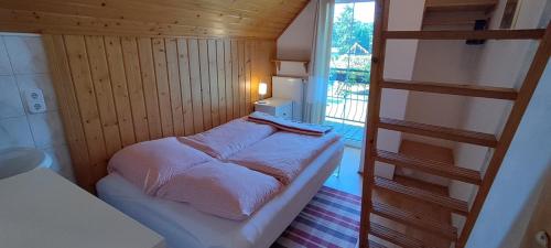 a small bed in a small room with a ladder at Dabki Village - Villa Rena in Dąbki