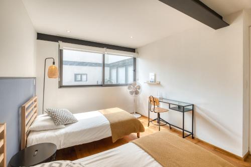 a bedroom with two beds and a window at Apartamentos Boutique La Condesa in Mexico City