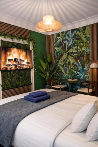 a bedroom with a large bed with a fireplace at Greenbrook Homes - Jungle Suite in Aalborg