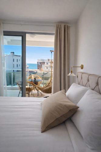 a bedroom with a bed with a view of the ocean at NUR Apartment in Dobra Voda
