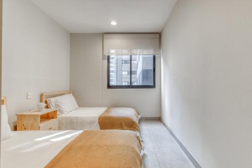 a small bedroom with two beds and a window at Polanco Business & Leisure - Junto a Embajada USA in Mexico City