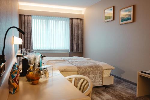 ein Hotelzimmer mit einem Bett und einem Tisch in der Unterkunft Hotel Casa56 in Weiswampach