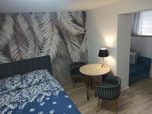 a bedroom with a bed and a table with chairs at Urban Palace bezpłatne miejsce postojowe in Wrocław