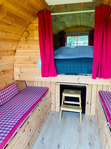 a inside of a wooden cabin with two beds and a ladder at Barrel Cabin 2 in Trethurgy