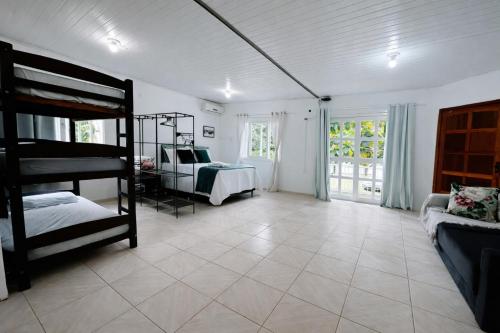 a room with two bunk beds and a couch at Refúgio até 8 pessoas Churrasqueira e pátio cercado in Arroio do Meio