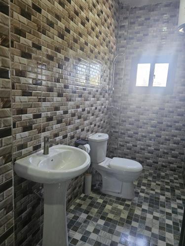a bathroom with a sink and a toilet at Yoyo Kunda in Banjul