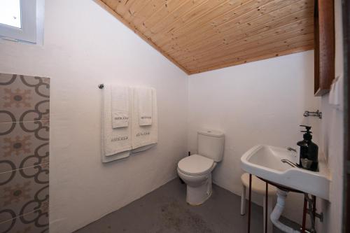 a white bathroom with a toilet and a sink at Cá Ficamos - T1 Hortacasa Portugal in Santiago do Cacém