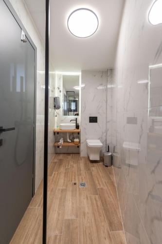 a bathroom with a shower and a toilet and a sink at Esperia Hotel in Larisa