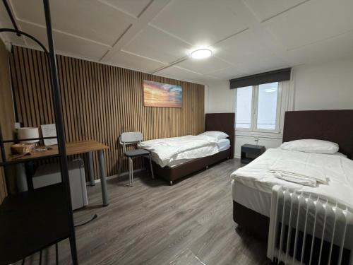 a hospital room with two beds and a desk and a table at SleepandGo in Zurich