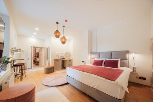 a bedroom with a large bed and a kitchen at Rozā Dāvids in Liepāja