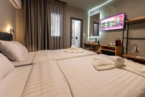a hotel room with two beds and a tv at Esperia Hotel in Larisa