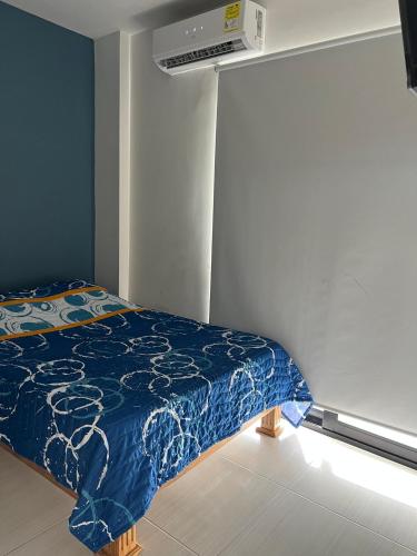 a bedroom with a bed with a blue comforter at Apartaestudio amoblado 303 Edificio Buenos Aires Sincelejo in Sincelejo