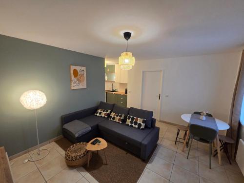 a living room with a couch and a table at Eden lodge Chessy - 10min Disneyland - Parking in Chessy