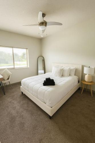 a bedroom with a large white bed with a fan at Blackbeam Suite in Des Moines