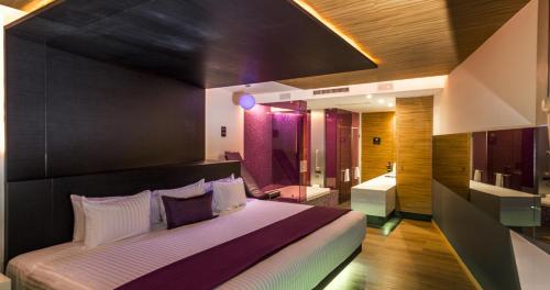 a bedroom with a large bed and a bathroom at V Boutique Periférico Sur in Mexico City